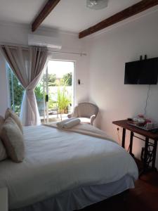 a bedroom with a large white bed and a window at Memories Vaaldam in Denysville