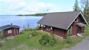 a log cabin on the shore of a lake at Saimaa Raikala in Vuoriniemi