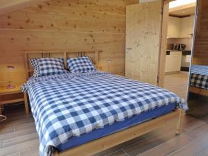 a bedroom with a blue and white checkered bed at Apartment beim Ahorn by Interhome in Kandersteg