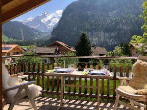 a table on a balcony with a view of a mountain at Apartment beim Ahorn by Interhome in Kandersteg