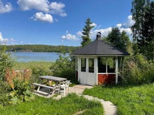 a gazebo with a picnic table and a bench at Saimaa Raikala in Vuoriniemi