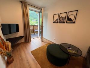 sala de estar con mesa, silla y TV en Apartment Apartement Haus Dankl by Interhome, en Fusch an der Glocknerstrasse