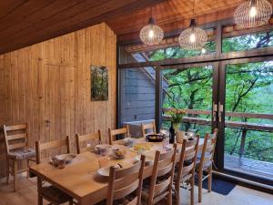 a dining room with a table and chairs and windows at Chalet Bosco della Bella - Casa 6 - ZUG by Interhome in Termine