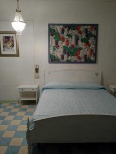 a bedroom with a bed and a painting on the wall at Fattoria la Ginestra, Museo della Civiltà Contadina in Fabriano