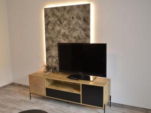 a flat screen tv sitting on top of a wooden entertainment center at Apartment Apart Hof Achenrainer by Interhome in Landeck
