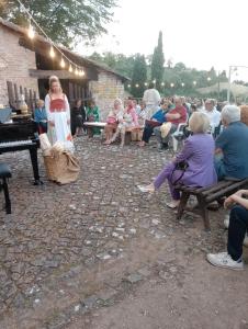 uma mulher em pé na frente de uma multidão de pessoas em Fattoria la Ginestra, Museo della Civiltà Contadina em Fabriano