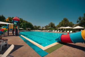 une piscine avec toboggan et un parc aquatique dans l'établissement Kampaoh Valledoria, à Valledoria