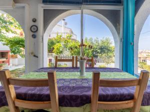 mesa con mantel púrpura, 2 sillas y ventana en Holiday Home Llimona by Interhome, en Creixell