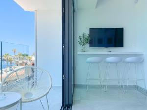 a living room with a bar with stools and a television at Phaedrus Living: Marina Sea View Flat 214 Emerald in Paphos