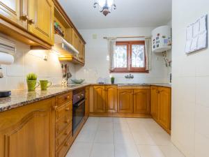 eine Küche mit Holzschränken und einem Fenster in der Unterkunft Holiday Home Llimona by Interhome in Creixell