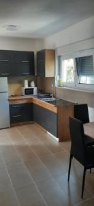 uma cozinha com um balcão, uma mesa e um lavatório em Apartments Miličević em Gradac