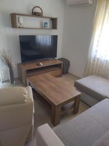 uma sala de estar com uma televisão e uma mesa de centro em Apartments Miličević em Gradac