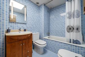 een blauw betegelde badkamer met een toilet en een wastafel bij Pedragosa in Sant Carles de la Ràpita