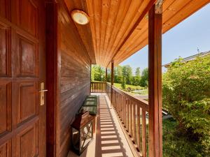 Casa de madera con porche con puerta de madera en Holiday Home Lesní plovárna B1 by Interhome, en Mladé Buky