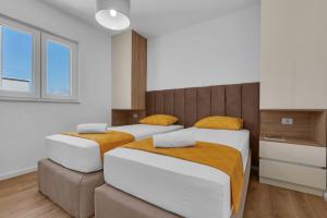 two beds in a room with white and brown at Dei apartment in Makarska