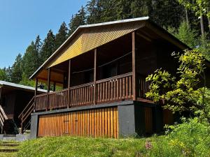 a large wooden house with a large deck at Holiday Home Lesní plovárna B1 by Interhome in Mladé Buky