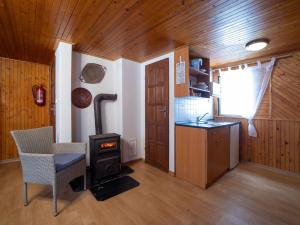 a kitchen with a stove and a table and a chair at Holiday Home Lesní plovárna B1 by Interhome in Mladé Buky