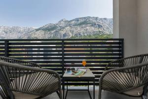 a table and two chairs with a drink on a balcony at Dei apartment in Makarska