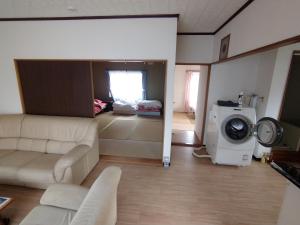 sala de estar con sofá y lavadora en メゾンドヴィラ en Kami-furano
