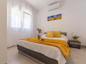 Un dormitorio con una cama con una manta amarilla. en Holiday Home Lola by Interhome, en Deltebre