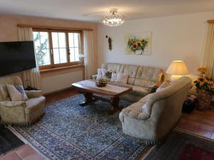 a living room with couches and a table and a tv at Holiday Home Chalet Bergnest by Interhome in Pragg-Jenaz