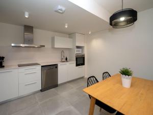 Una cocina con gabinetes blancos y una mesa de madera. en Apartment Waves by Interhome, en Calafell