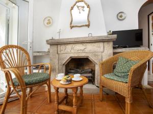 een woonkamer met 2 stoelen en een open haard bij Holiday Home Marie by Interhome in L'Escala