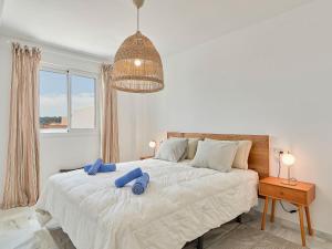 a bedroom with a bed with two blue pillows on it at Apartment Doña Julia Golf Views by Interhome in Bahia de Casares