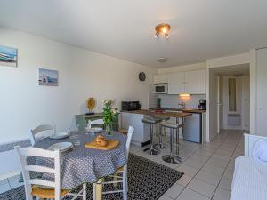 een eetkamer en keuken met een tafel en stoelen bij Apartment Les Eiders by Interhome in Carnac