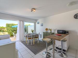 een keuken met een tafel en een eetkamer met een raam bij Apartment Les Eiders by Interhome in Carnac