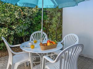 een tafel met een fruitmand en een paraplu bij Apartment Les Eiders by Interhome in Carnac