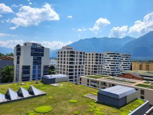 - une vue sur une ville avec de grands bâtiments et de l'herbe dans l'établissement Apartment Torre Tessuti 3-2 by Interhome, à Locarno