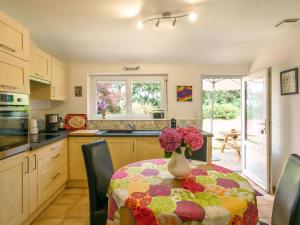 a kitchen with a table with a vase of flowers on it at Holiday Home Ty Naïg by Interhome in Pouldreuzic