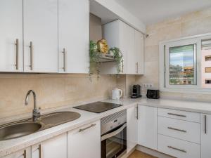 a kitchen with white cabinets and a sink and a window at Apartment Atria-3 by Interhome in Torremolinos