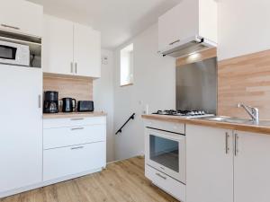 una cucina con armadi bianchi e lavandino di Apartment Sù la plage by Interhome a Portbail
