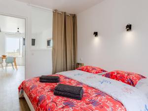 una camera da letto con un letto rosso con due asciugamani di Apartment Sù la plage by Interhome a Portbail