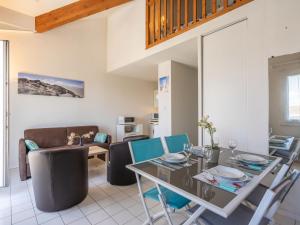 una sala da pranzo e un soggiorno con tavolo e sedie di Studio Parc de Pontaillac-29 by Interhome a Vaux-sur-Mer