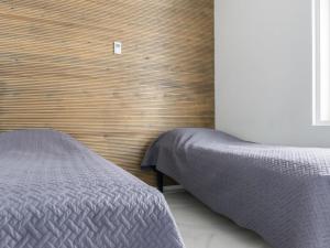 a bedroom with a bed and a wooden wall at Holiday Home Villa hirvas by Interhome in Salmentaka