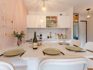- une cuisine avec une table et des chaises ainsi qu'une bouteille de vin dans l'établissement Apartment Le Clos Mathilde-20 by Interhome, à Cabourg 15 autres photos