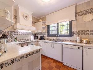 uma grande cozinha com electrodomésticos brancos e uma janela em Holiday Home El Garrofer by Interhome em Comarruga