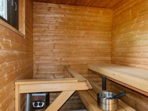 a wooden sauna with two benches and a bucket at Holiday Home Mäkitupa by Interhome in Syöte