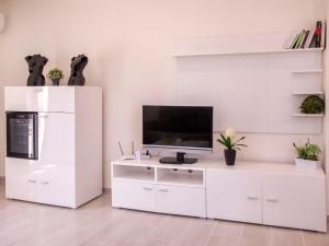 a white living room with a television on a white cabinet at Holiday Home Baruffa by Interhome in Jávea