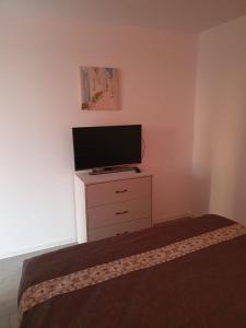 um quarto com uma televisão de ecrã plano numa cómoda em Sunset View em Costinesti