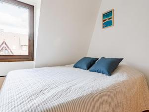 een slaapkamer met een bed met twee blauwe kussens erop bij Apartment l'Hermitage-3 by Interhome in Deauville