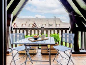 een terras met een tafel en stoelen op een balkon bij Apartment l'Hermitage-3 by Interhome in Deauville