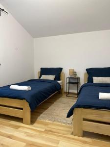 sypialnia z 2 łóżkami z niebieską pościelą i stołem w obiekcie Mirabella House w mieście Rzeszów