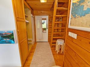 pasillo con escalera en una habitación con paredes de madera en Holiday Home Alakitkanranta by Interhome, en Kuusamo