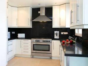 a kitchen with white cabinets and a stove top oven at Villa Pax et Lucis by Interhome in Benissa