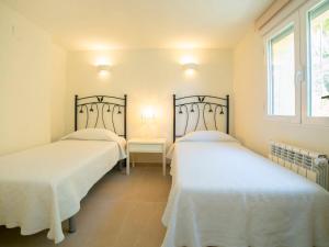 two beds in a room with a table and a window at Villa Pax et Lucis by Interhome in Benissa