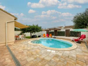 una piscina en un patio con sillas y sombrillas en Holiday Home La Voie Romaine by Interhome, en Sauvian